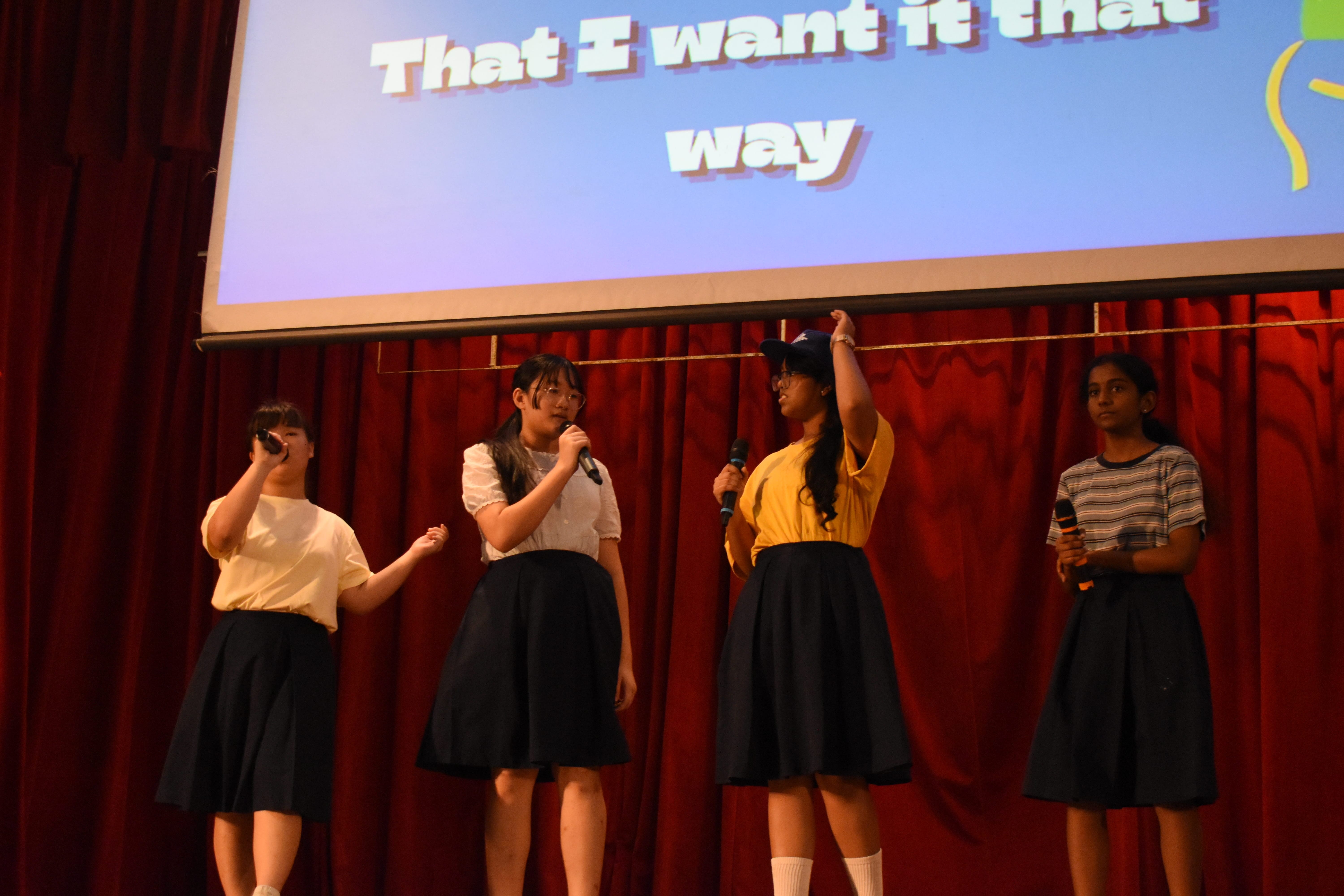 4 students singing onstage